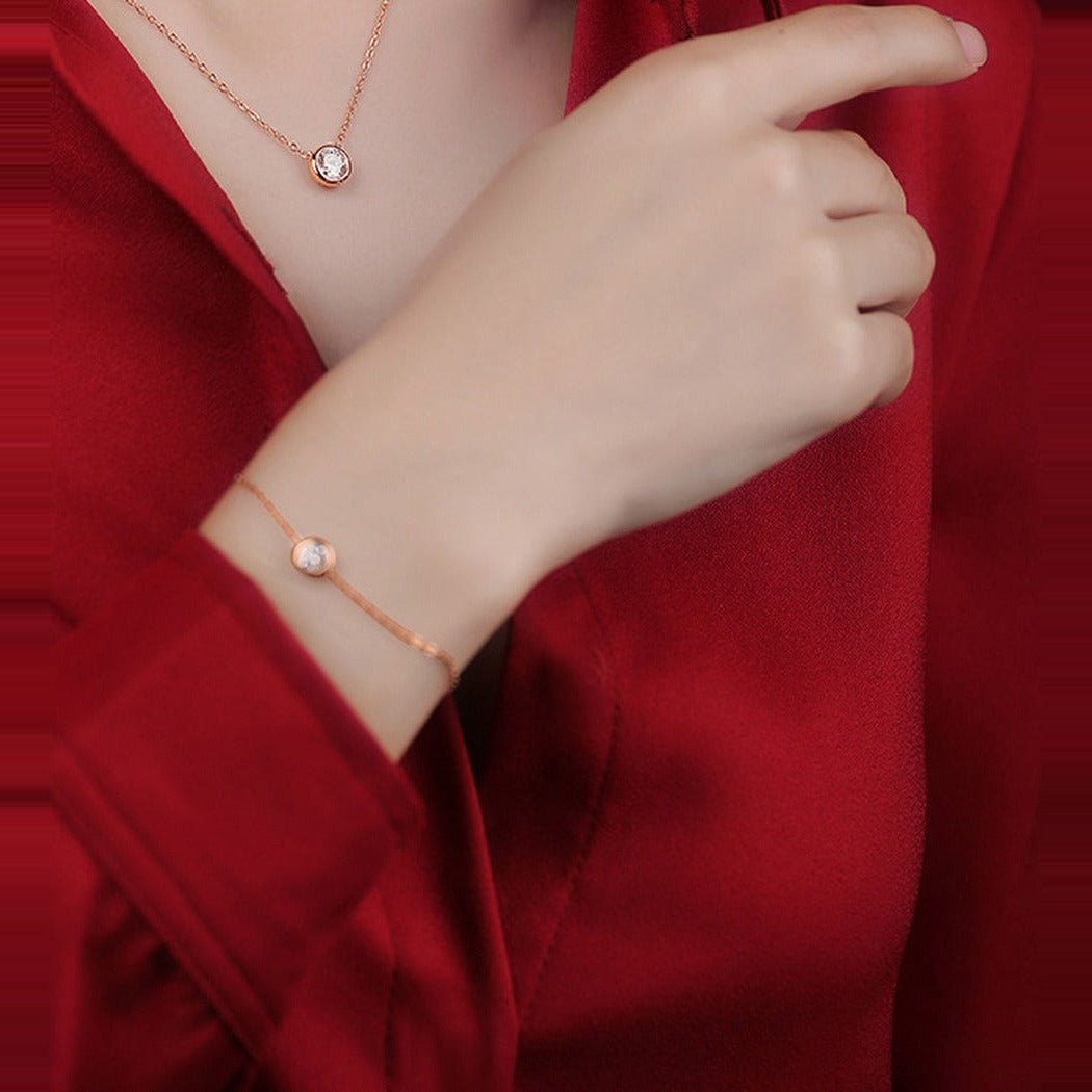 Bracelet Bulle Kouchta — porté au poignet avec le collier assorti, finition or rose