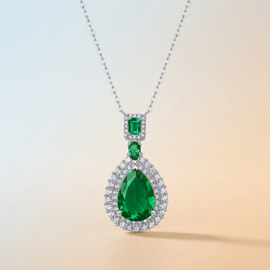 Collier goutte Kouchta : émeraude poire, émeraude rectangulaire et émeraude ronde, halos pavés