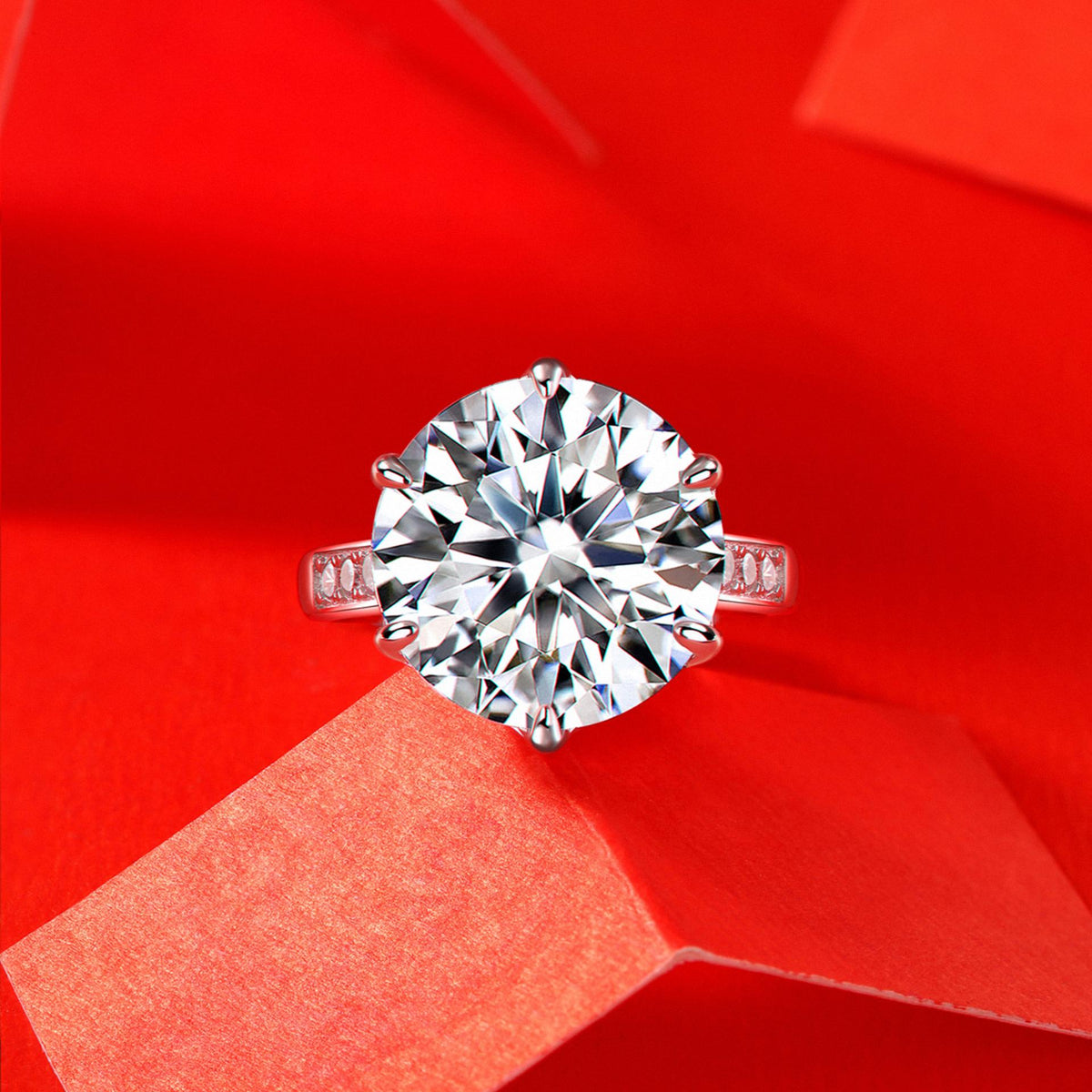 Kouchta Solitaire Six Griffes Spectaculaire — bague sur fond rouge facetté, mise en scène dramatique